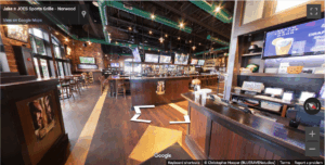 Interior of Jake n Joes sports bar with a central bar, TVs, high tables, and industrial-style lighting.