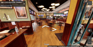 Dining area at Jake n JOES Braintree with wooden tables, TVs, and hexagonal ceiling lights.